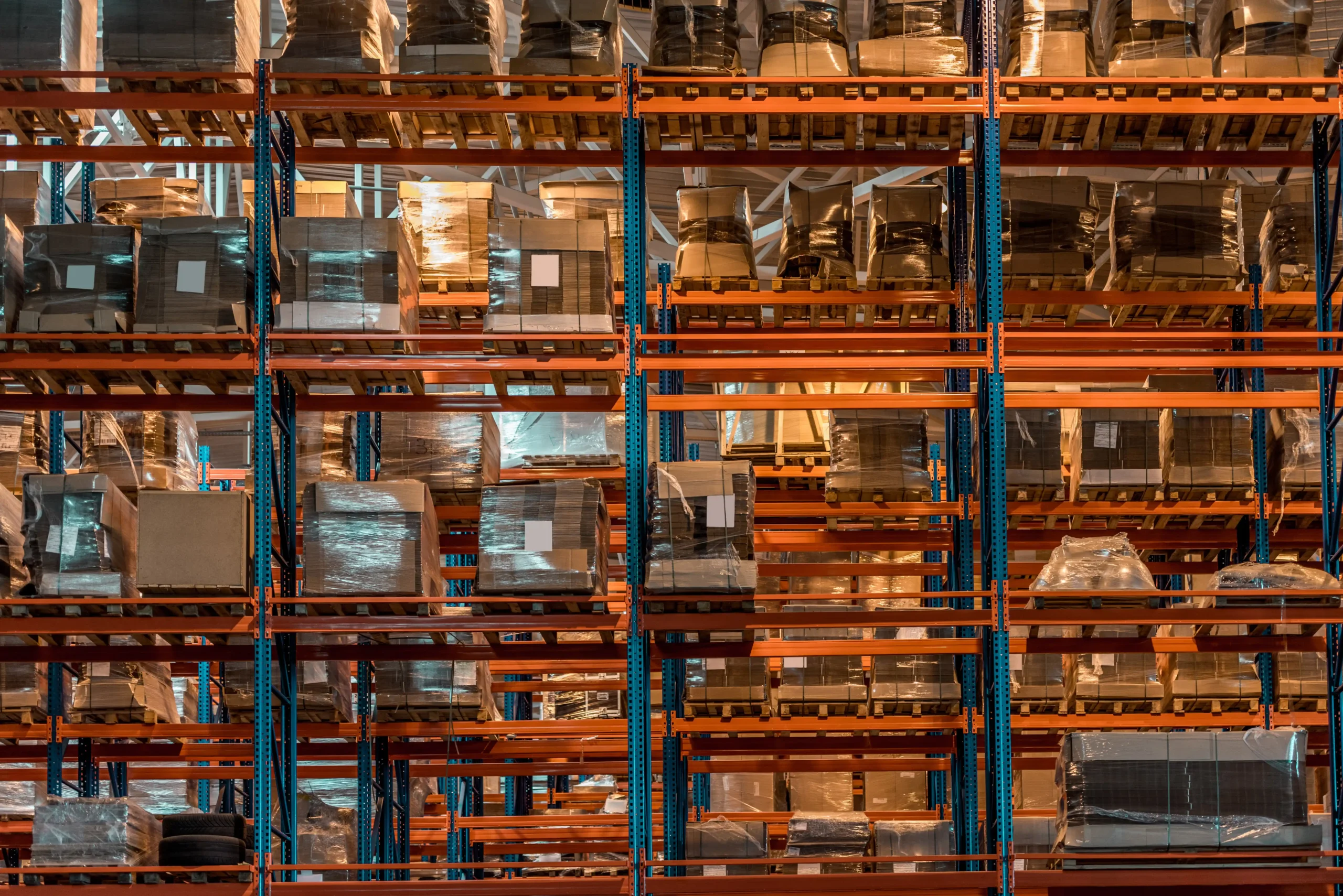 Rows of pallets and boxes stacked on a warehouse storage rack system designed for high-density inventory storage.