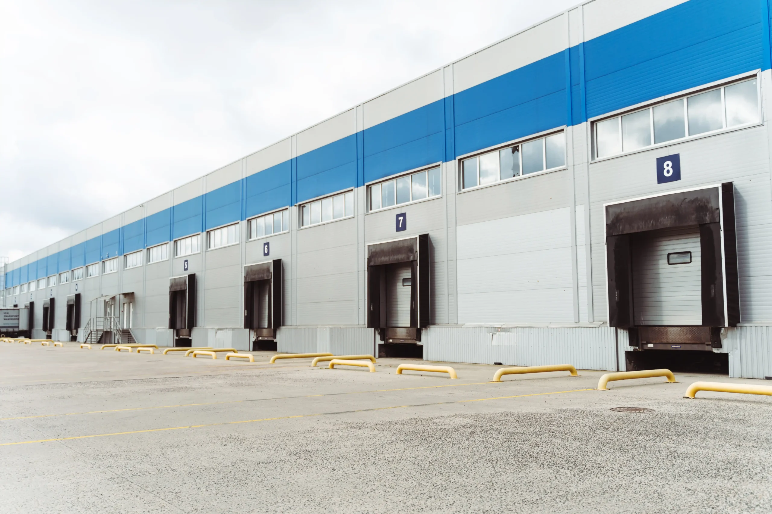 Exterior view of a warehouse storage building featuring numbered loading dock doors for efficient truck receiving and shipping.