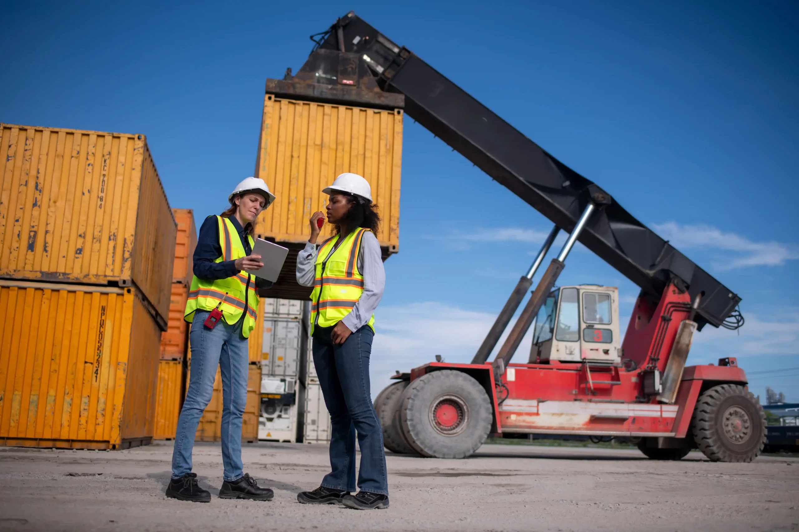 Logistics professionals overseeing container handling and cargo movement at a warehouse and distribution near me location