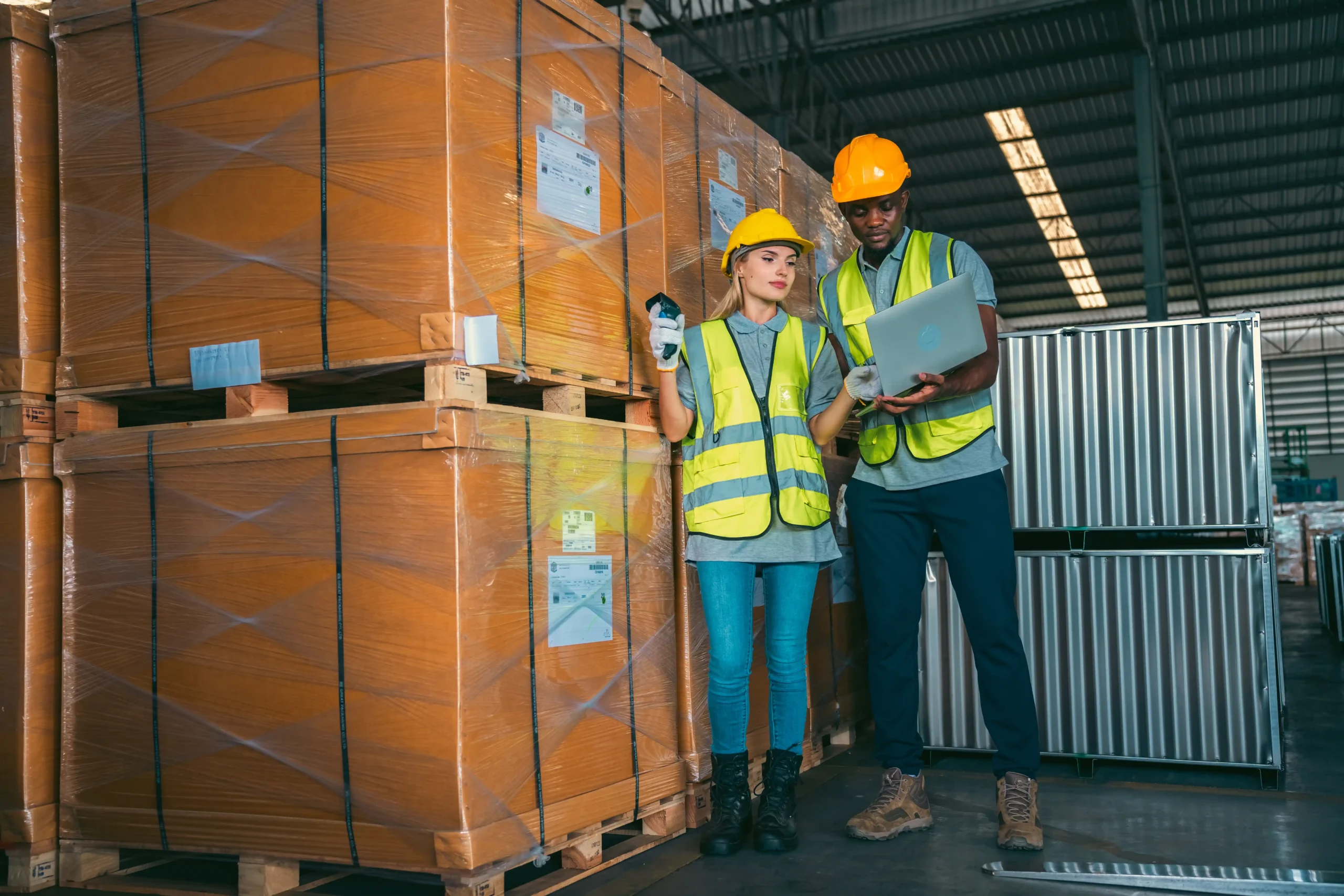 Two warehouse workers using a laptop and scanner to manage pallets in a facility designed for long term warehouse storage.