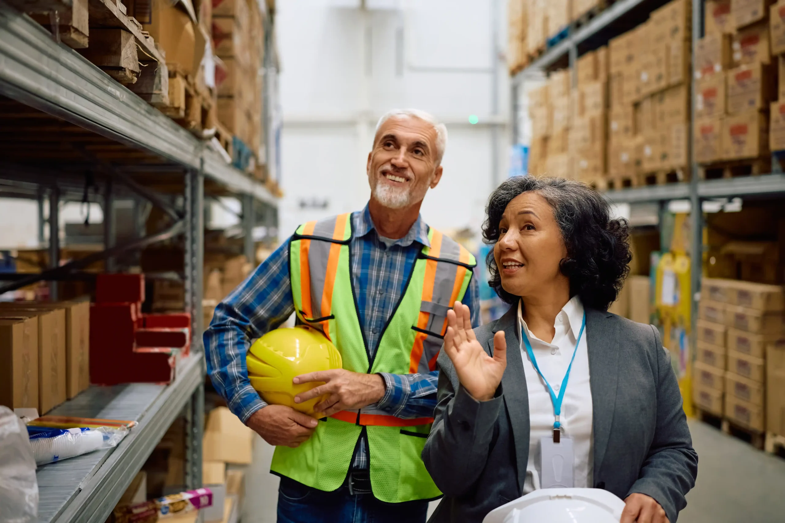 Warehouse logistics optimization in action as a warehouse manager and inspector review inventory flow and safety procedures on the warehouse floor.