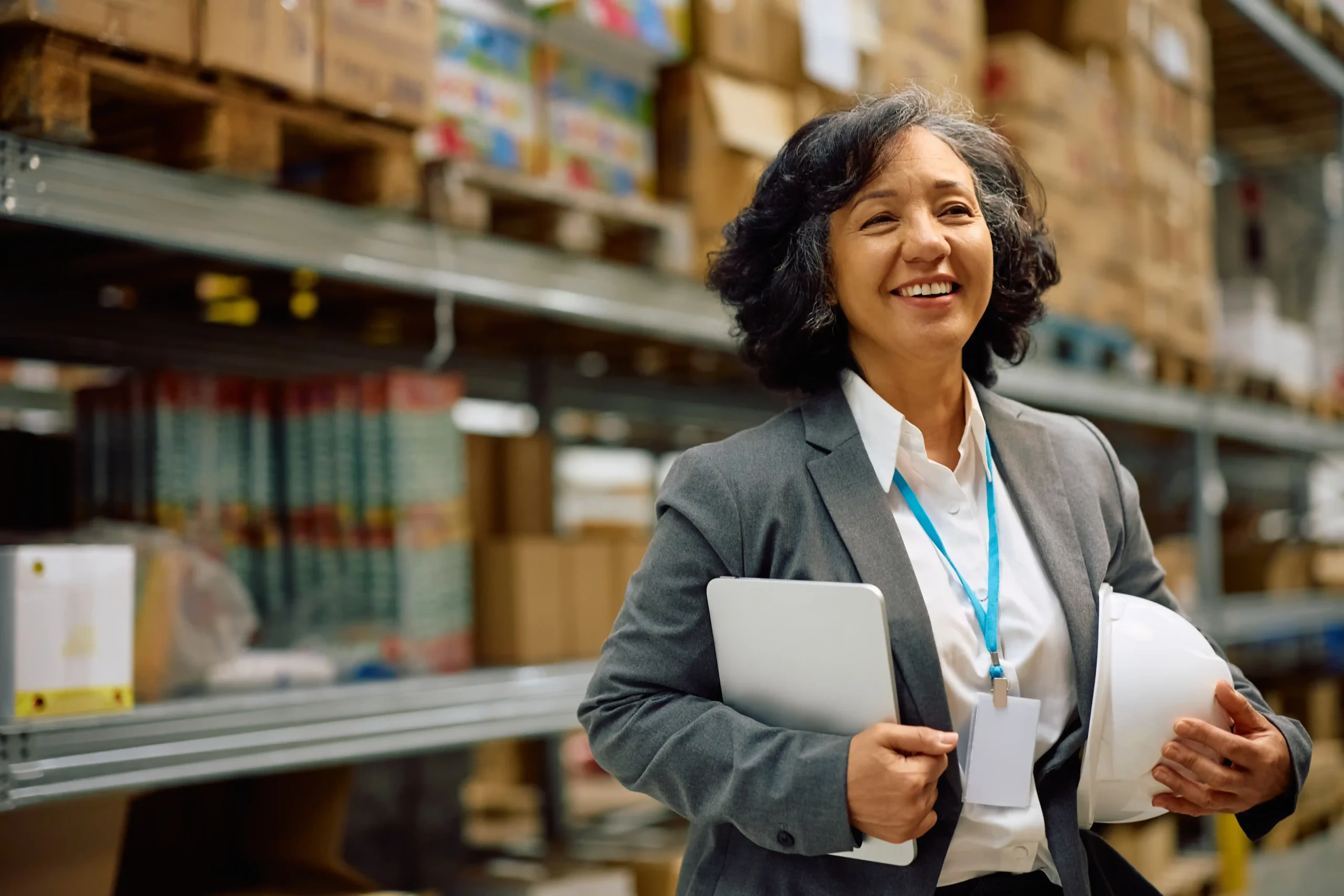 Warehouse and logistics specialist walking through a distribution warehouse while overseeing inventory and daily operations