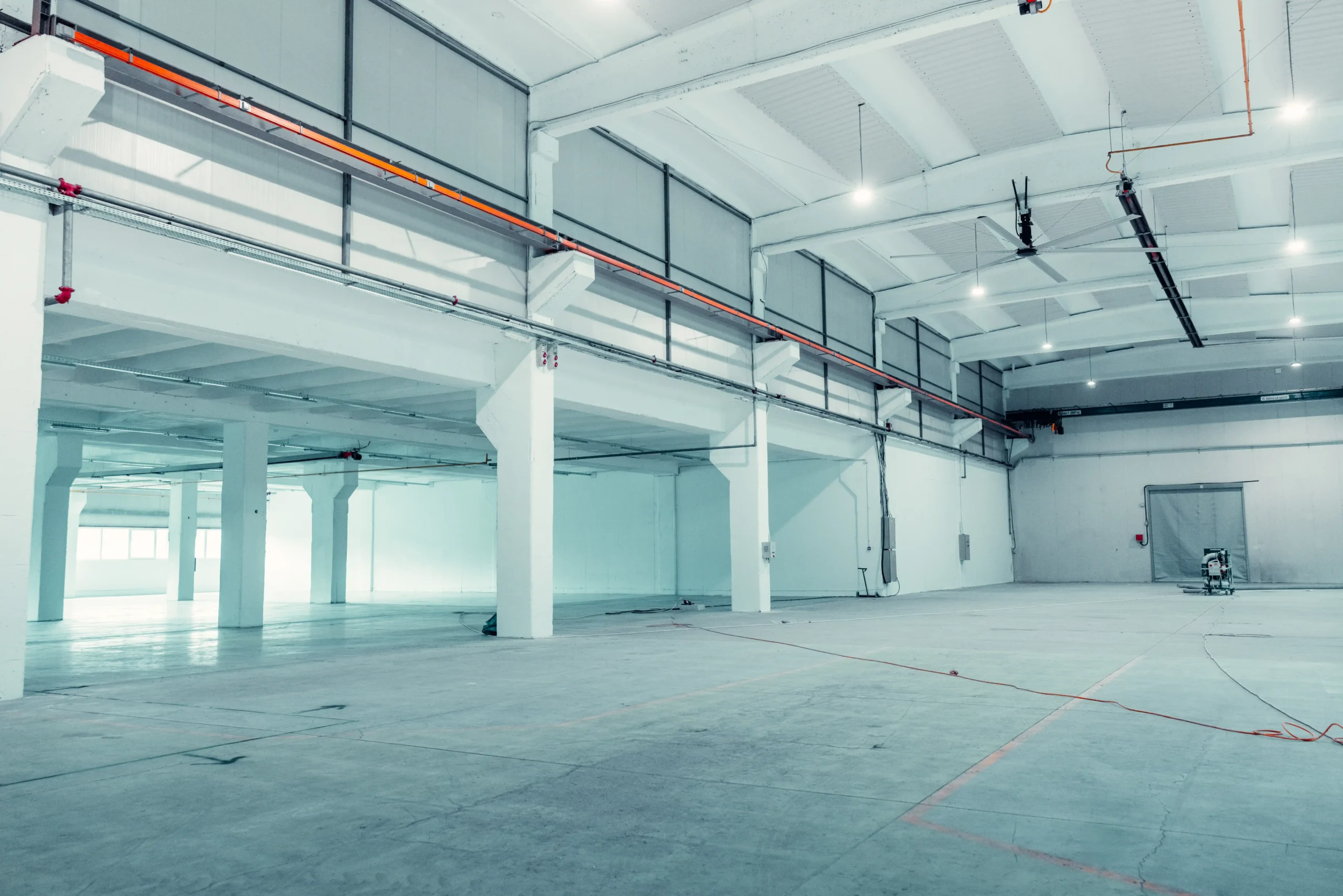 Empty industrial warehouse under construction with clean concrete floors, showing flexible build-out options in small warehouse units for rent.