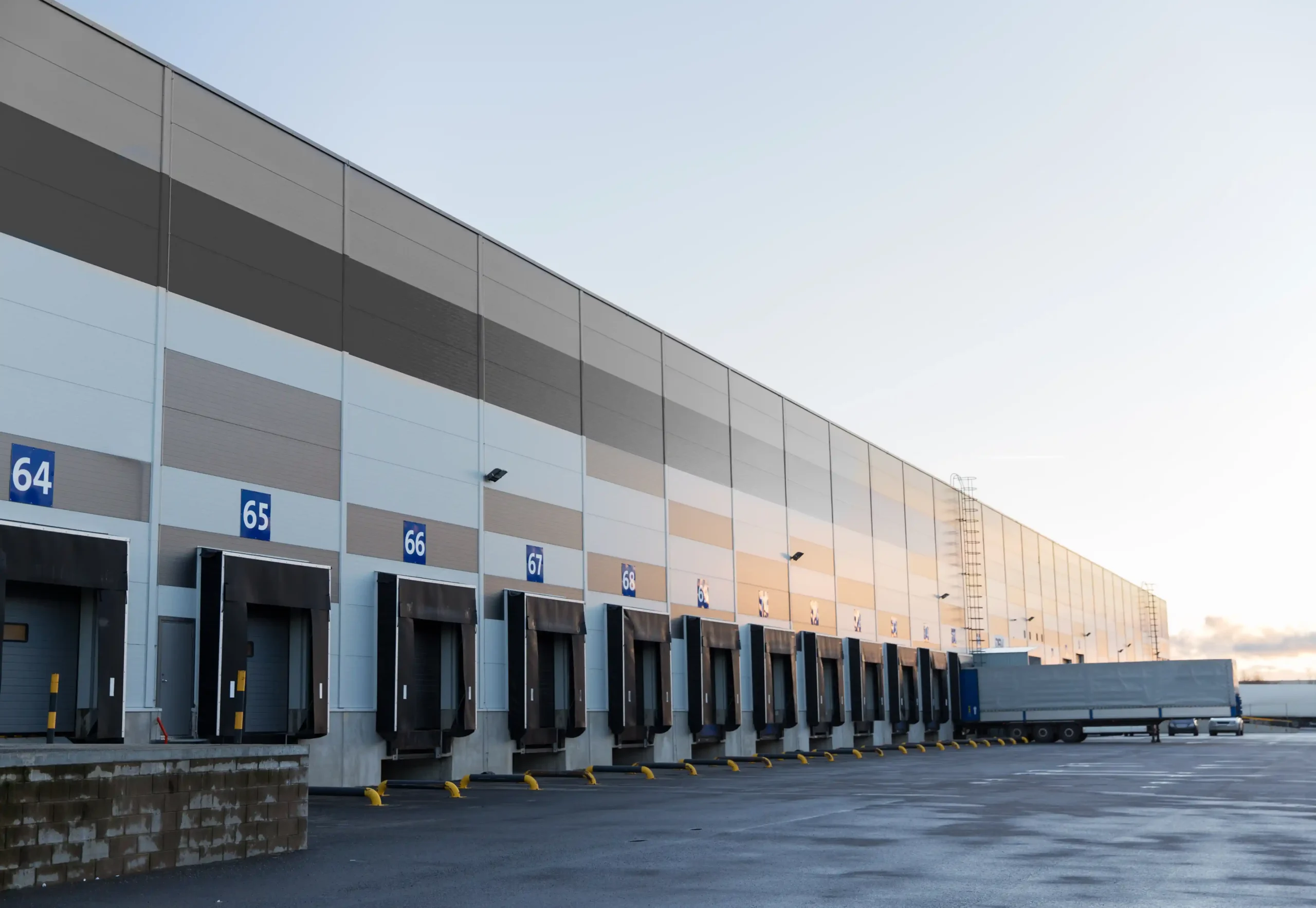 Wide-angle view of a warehouse storage building showing multiple dock bays designed for logistics, freight handling, and distribution.