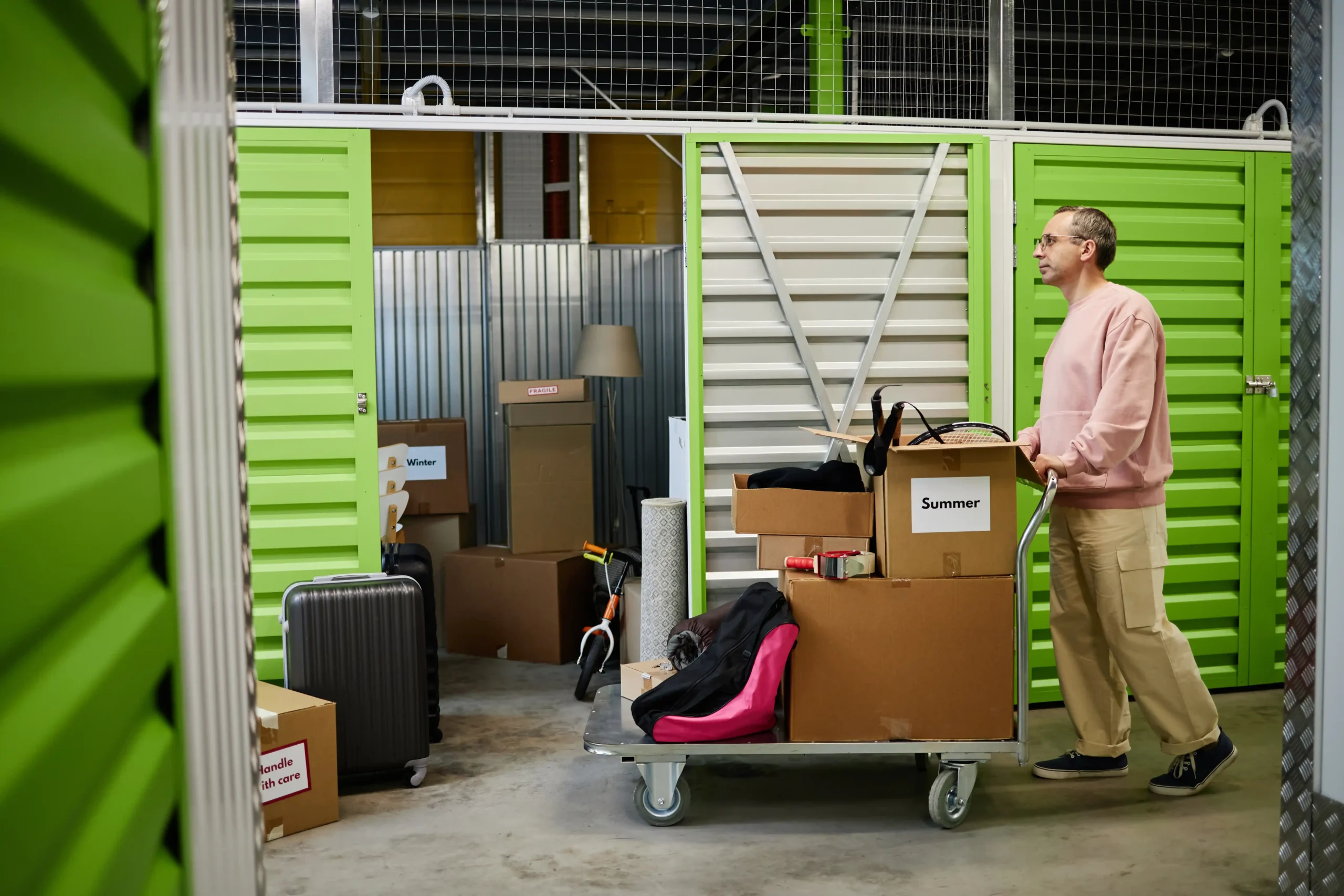 Man sorting boxes and seasonal inventory inside a compact unit designed for small warehouse storage organization and space optimization.