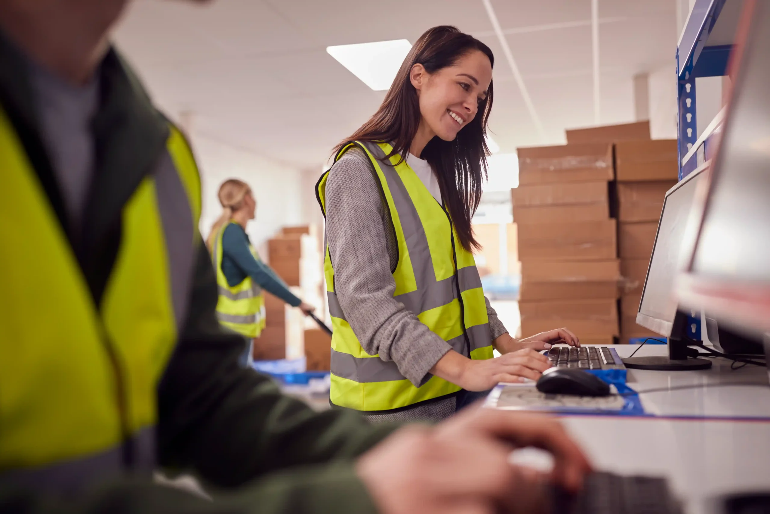 Warehouse staff using computer systems to track orders and inventory, demonstrating how technology supports fulfillment expense visibility.