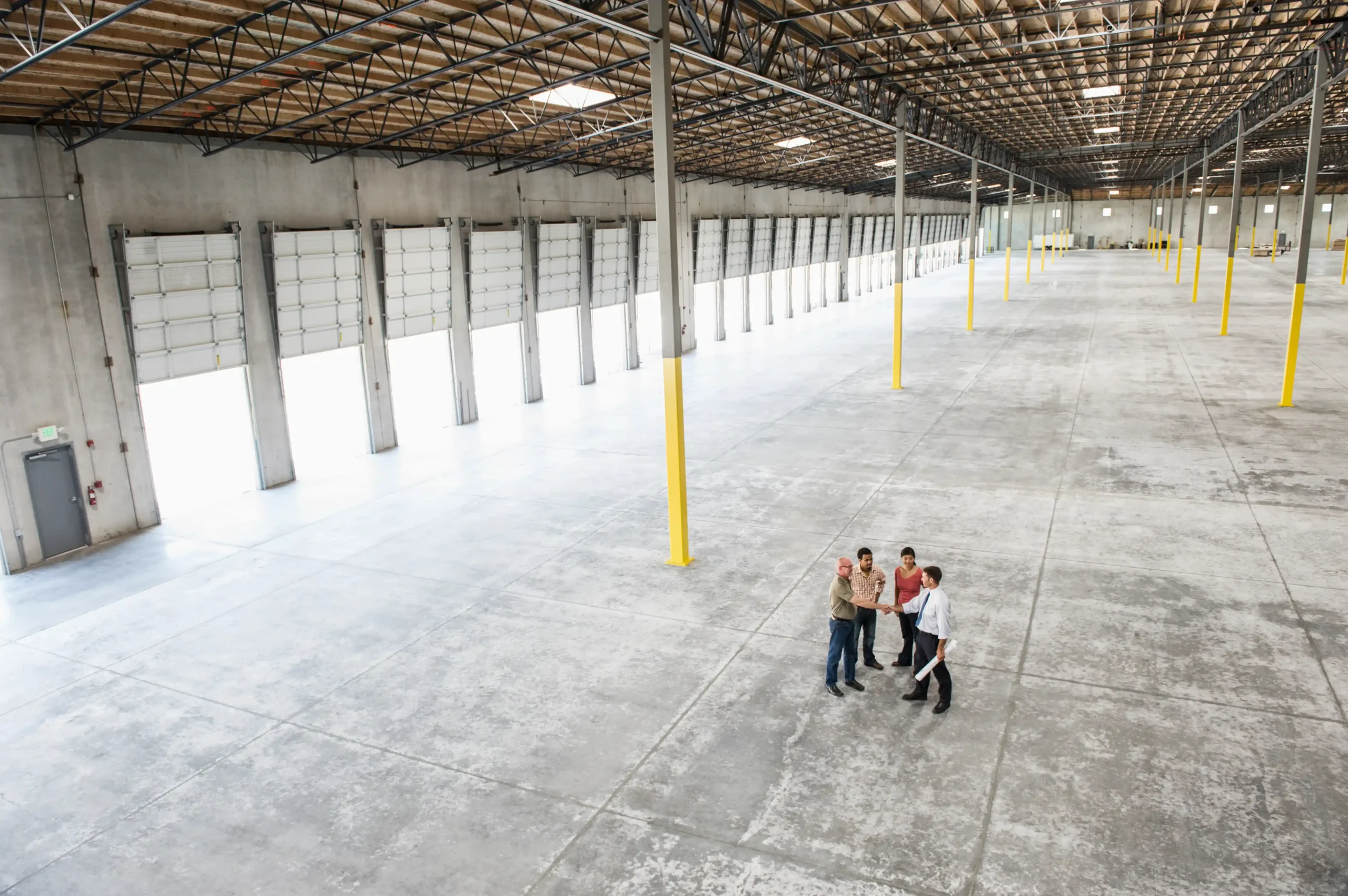 Wide interior of newly constructed warehouse storage buildings featuring multiple loading bays and open floor space.