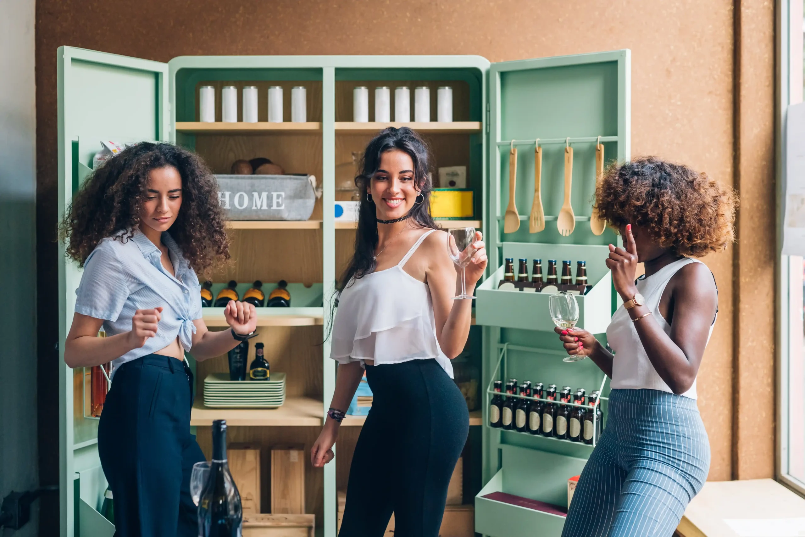 Three women enjoying wine in a modern setting, showcasing how reliable commercial wine storage ensures quality for tasting and service.