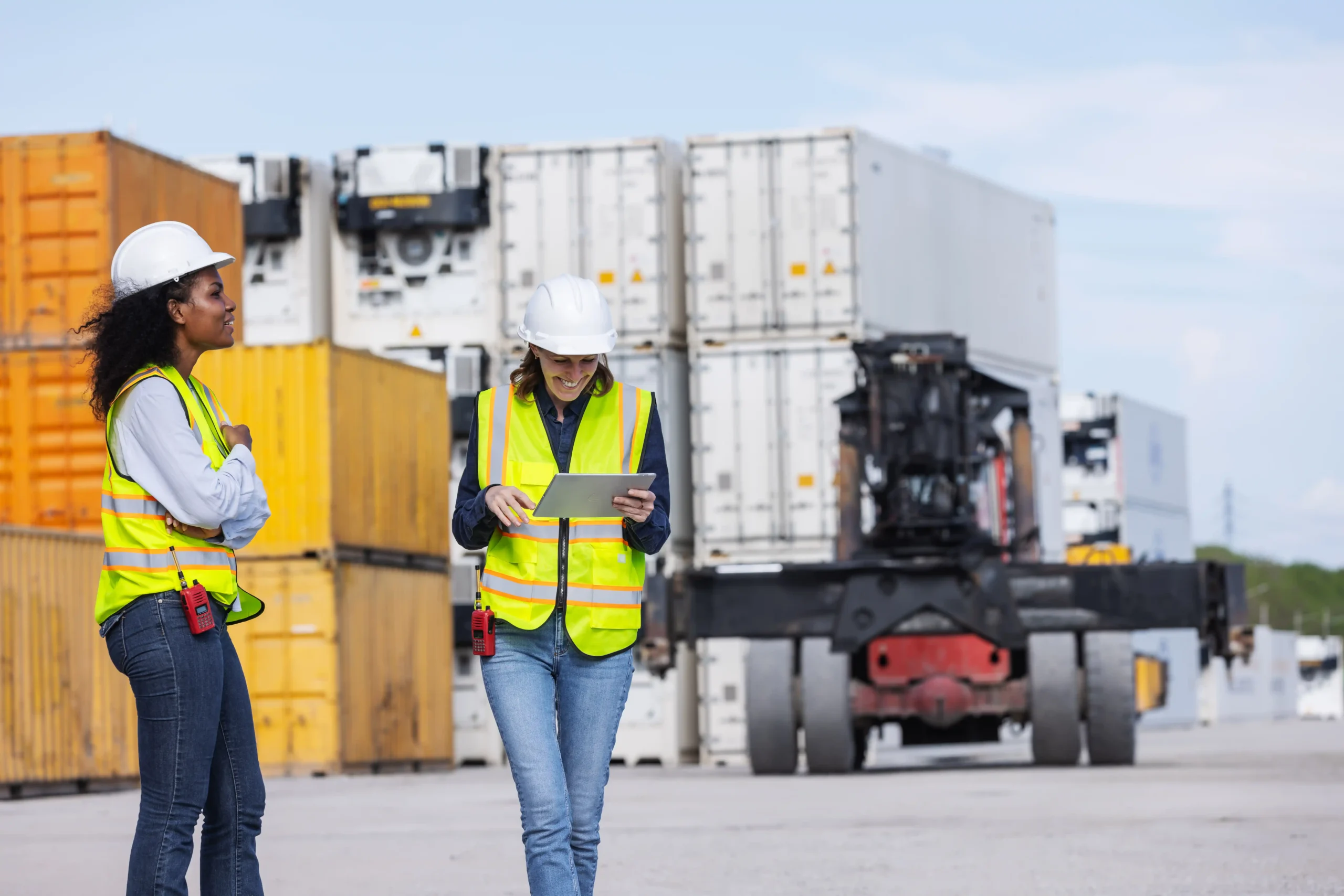 Logistics coordinators reviewing container data on a tablet, showing are logistics and supply chain the same in global trade environments