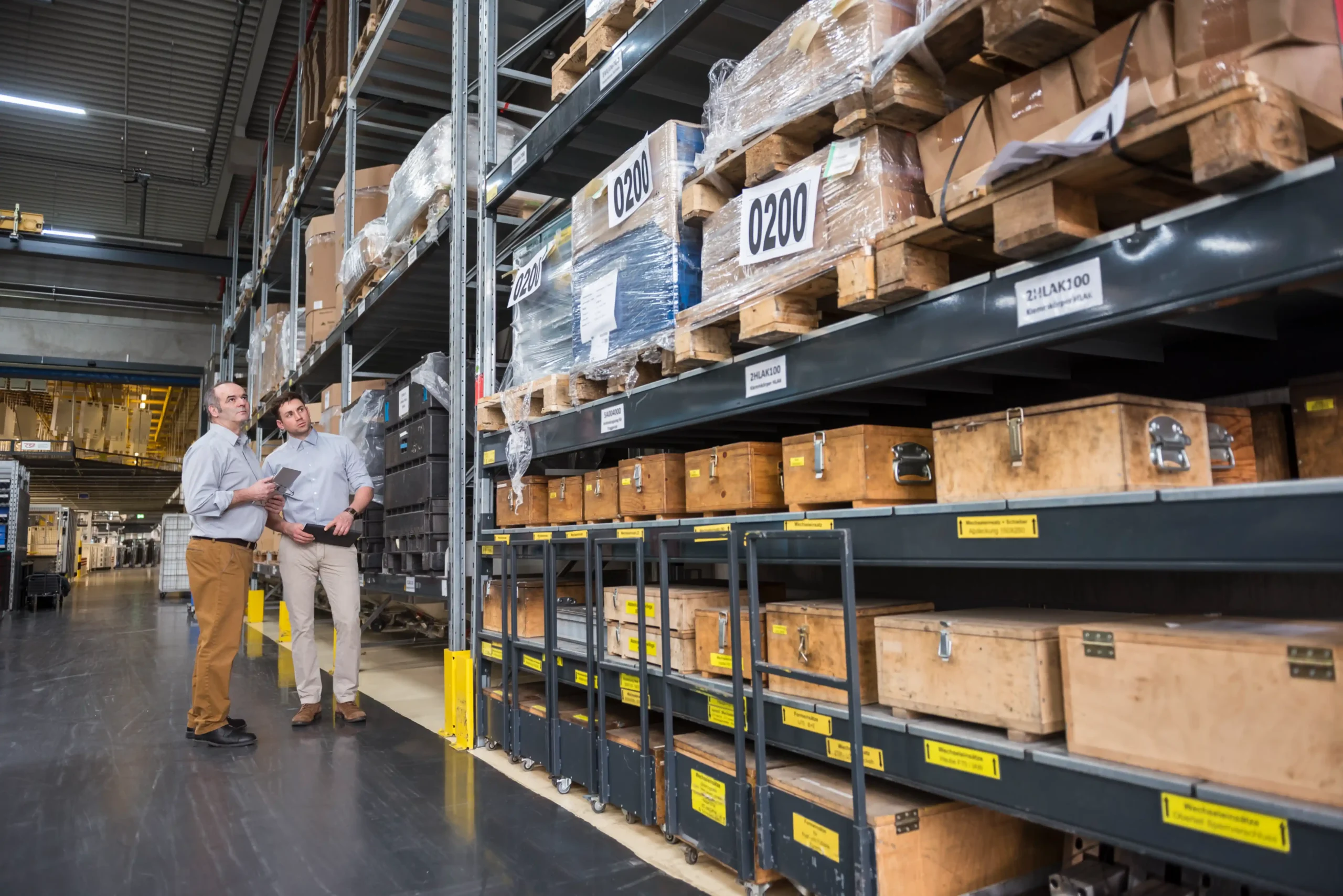 Warehouse manager discussing storage layout in an industrial facility that relies on bins for warehouse storage for better efficiency.