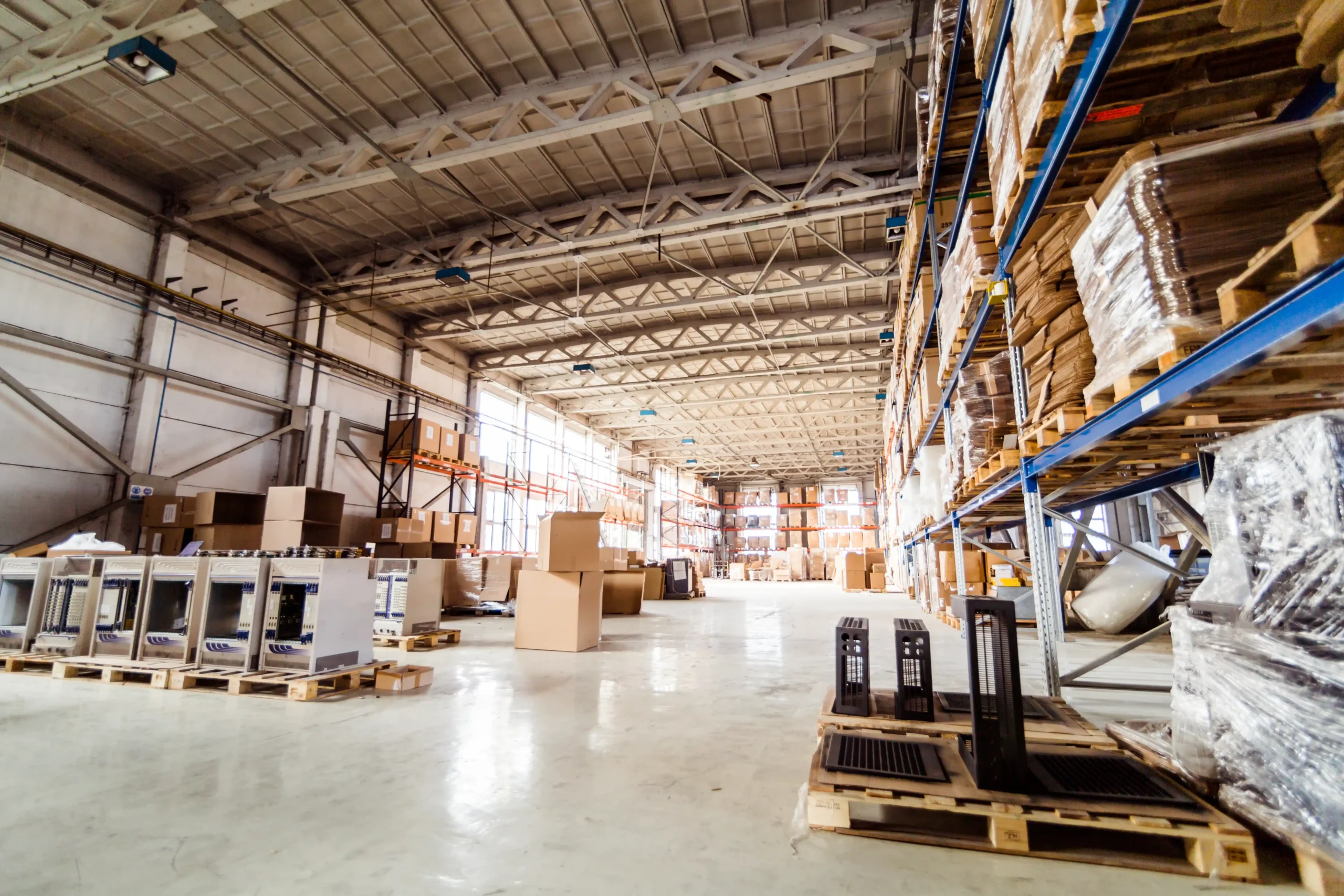 Busy warehouse with pallets and shelving systems, showing operational flow typical of small warehouse units for rent.