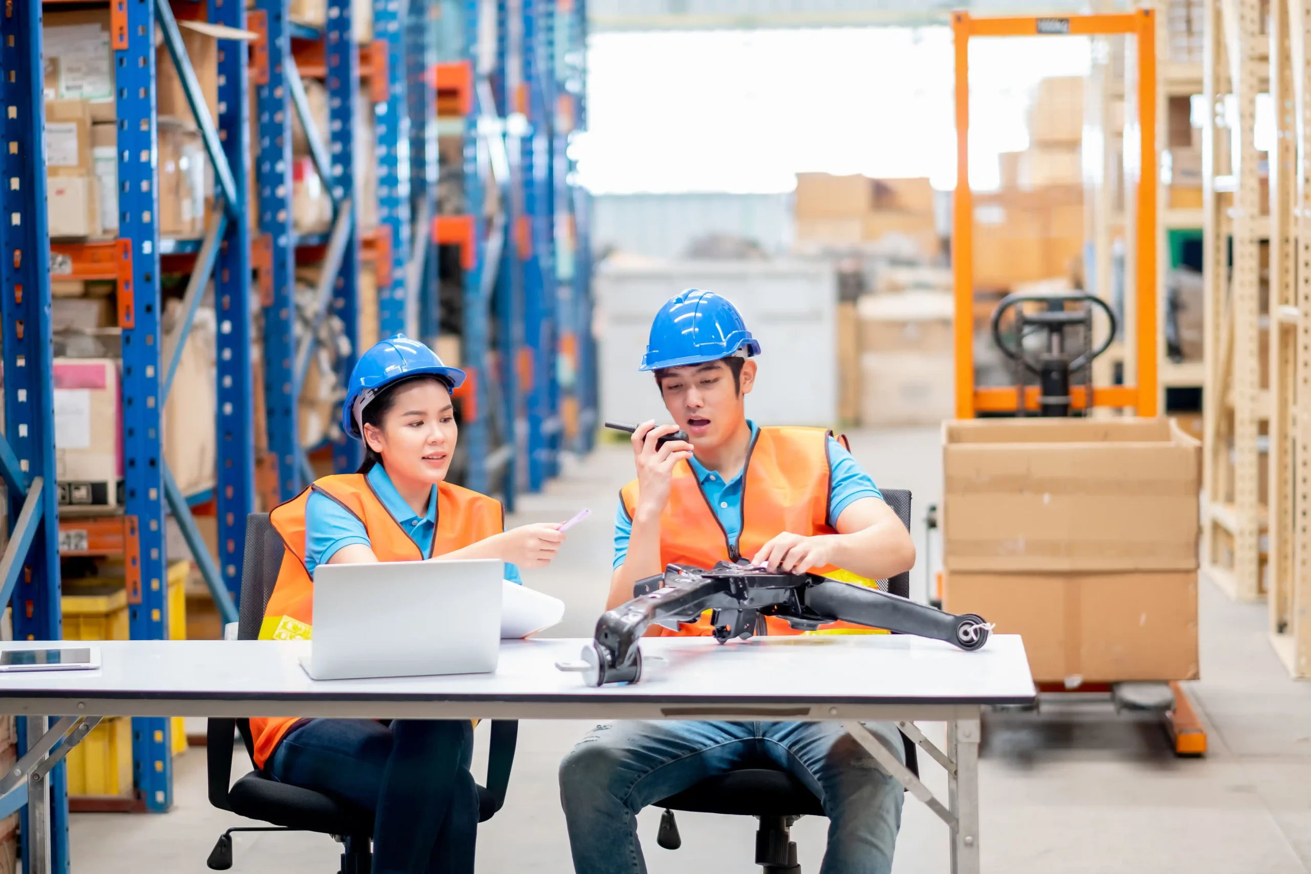 Warehouse workers reviewing documentation and equipment during practical lessons from warehouse and logistics courses