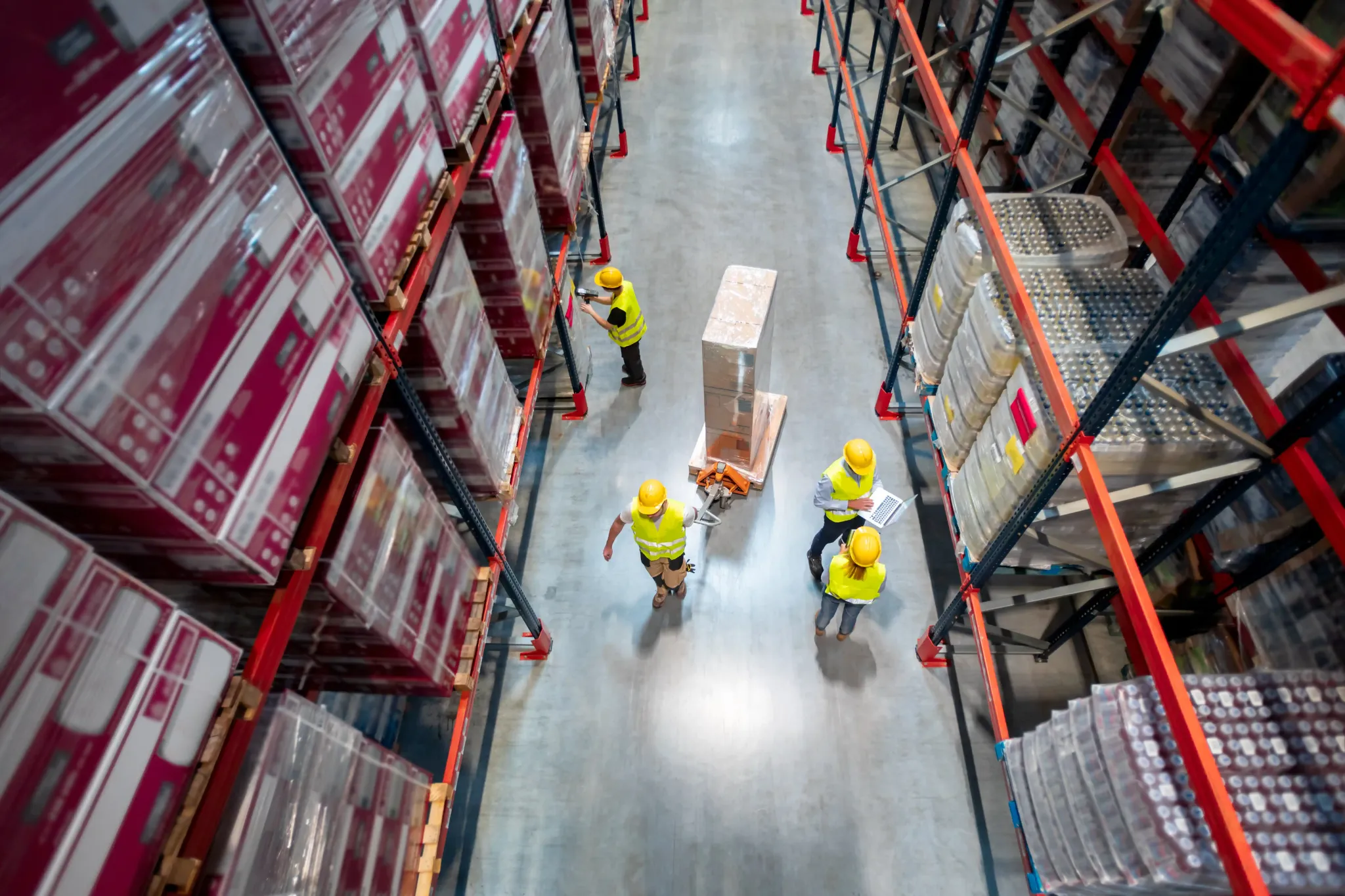 Top view of warehouse staff moving pallets as part of organized warehouse and storage services processes.